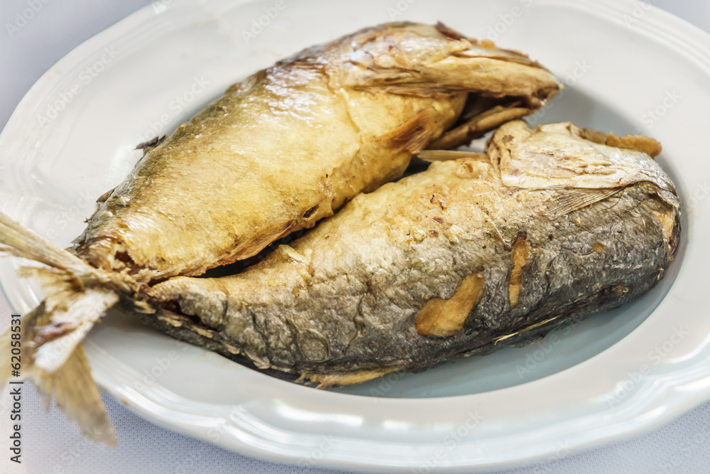 Pan fried mackerels on white plates Pan fried mackerels on white plates