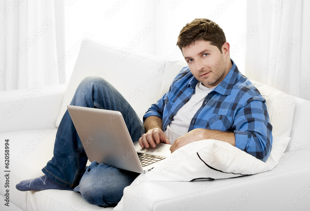 Attractive man with computer sitting on couch Attractive man with computer sitting on couch