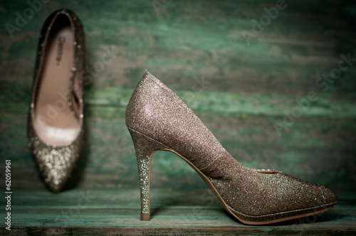 Golden women shoes on wooden background