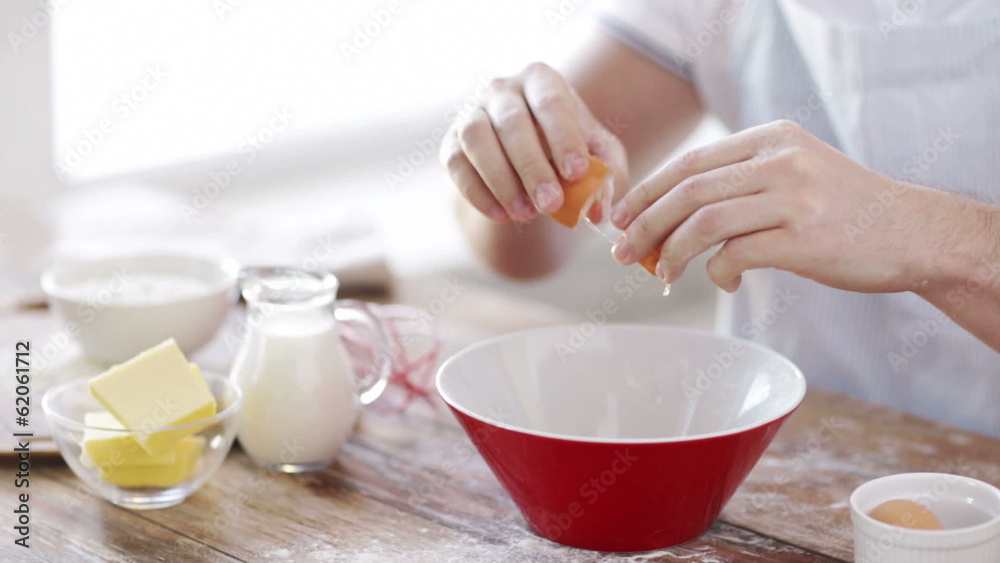 close up of male hands cracking an eggl