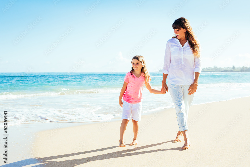 Happy mother and young daughter walking on the beach Happy mother and young daughter walking on the beach