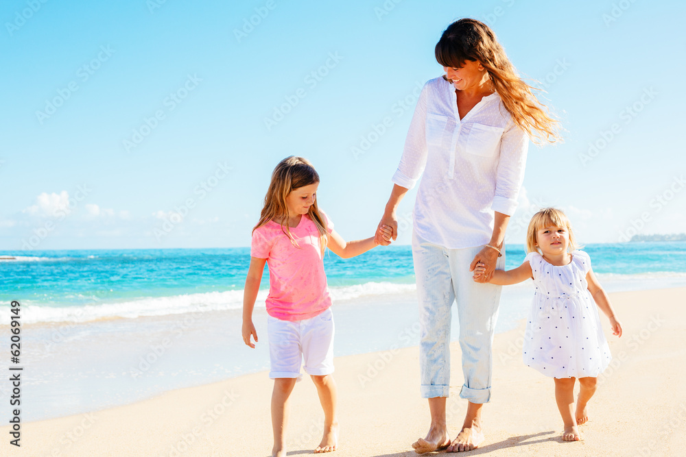 Mother daughters walking on the beach