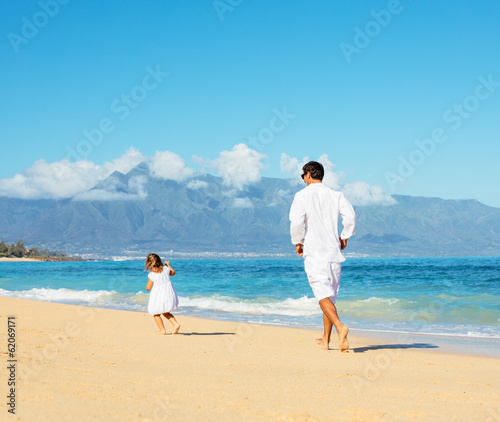 Father and daughter walking together at the beach