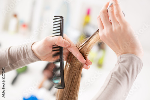 Hairdresser cut hair of a woman.