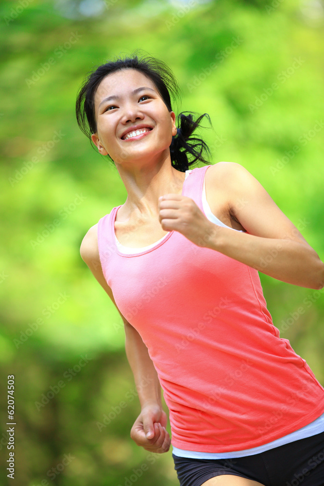 Fototapeta premium young asian woman running at tropical park 