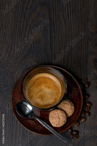 glass of espresso, almond cookies on dark background, top view