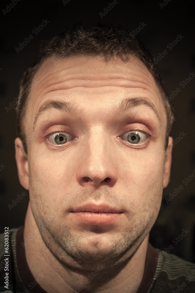 Obraz premium Shocked young Caucasian man portrait on dark background