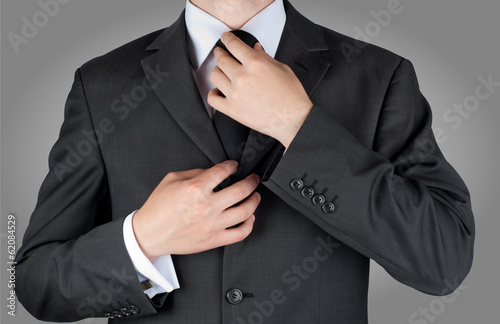 businessman in black costume tie one's necktie