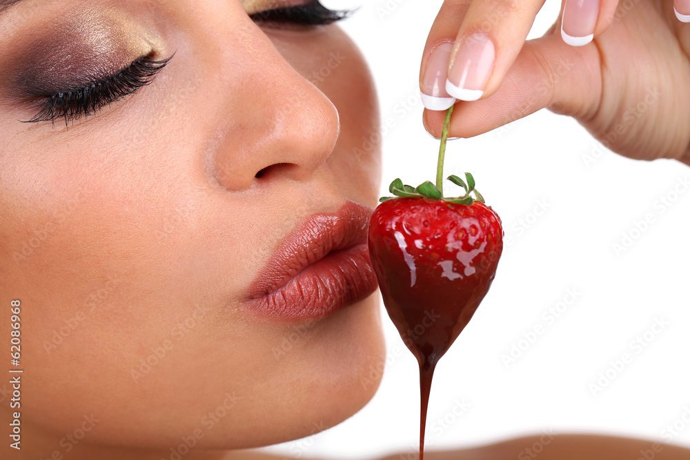 Closeup of woman eating strawberry in chocolate Closeup of woman eating strawberry in chocolate