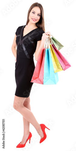 Beautiful young woman holding shopping bags isolated on white