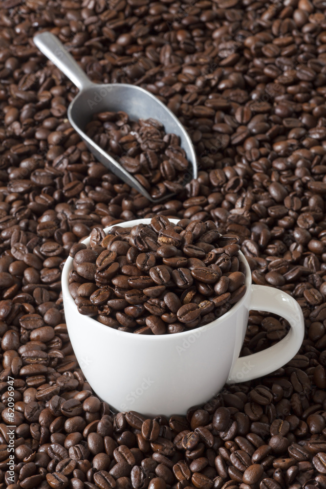 Kaffeetasse mit Kaffeebohnen und eine Kaffeeschaufel Kaffeetasse mit Kaffeebohnen und eine Kaffeeschaufel