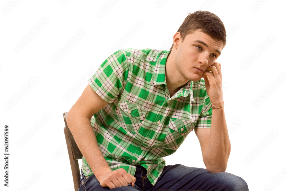 Watchful young man sitting thinking