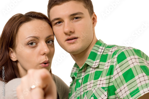 Young couple pointing at the camera