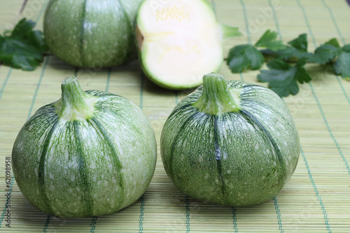 Round zucchini on a green bamboo tablecloth