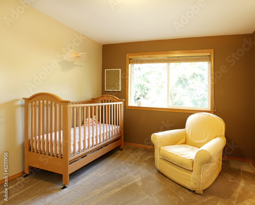 Baby room with crib and yellow chair.