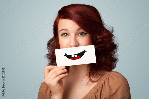 Happy pretty woman holding card with funny smiley