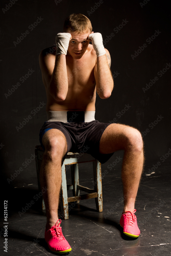 Boxer sitting on a stool with his fists raised