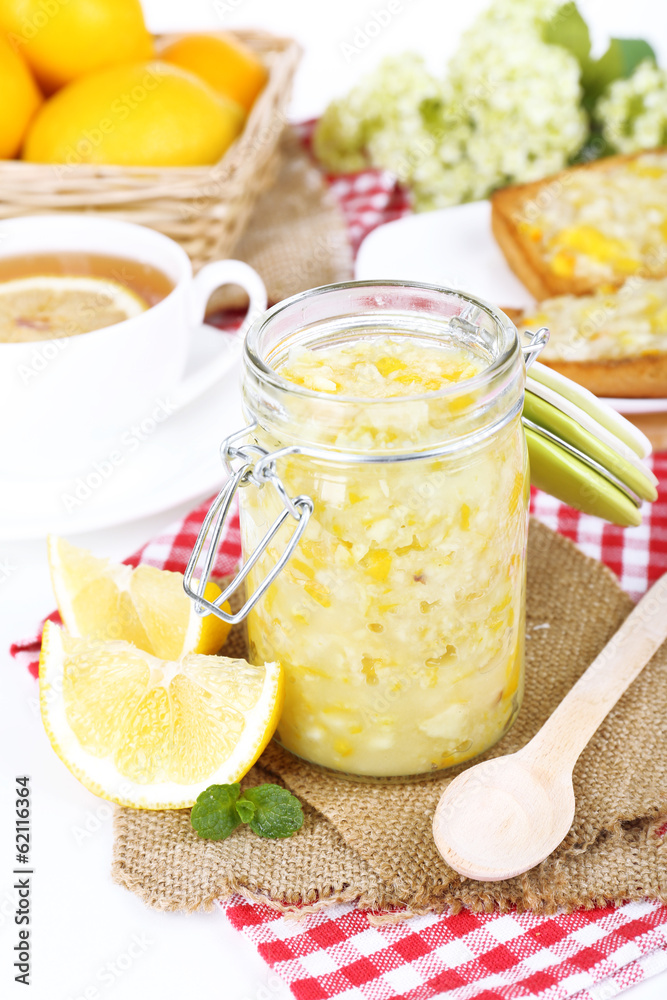 Tasty lemon jam with cup of tea on table close-up Tasty lemon jam with cup of tea on table close-up