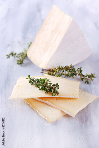 Tasty Camembert cheese with thyme, on wooden table