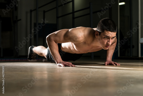 Young Man Doing Press Ups In Gym