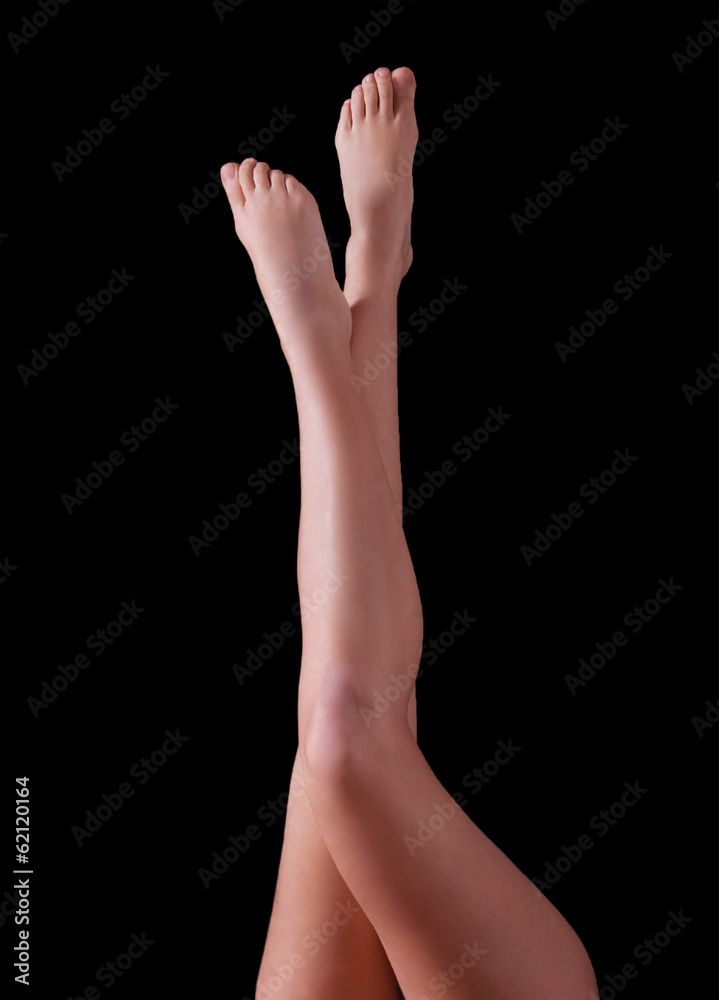 Slender female legs, isolated on black background Slender female legs, isolated on black background