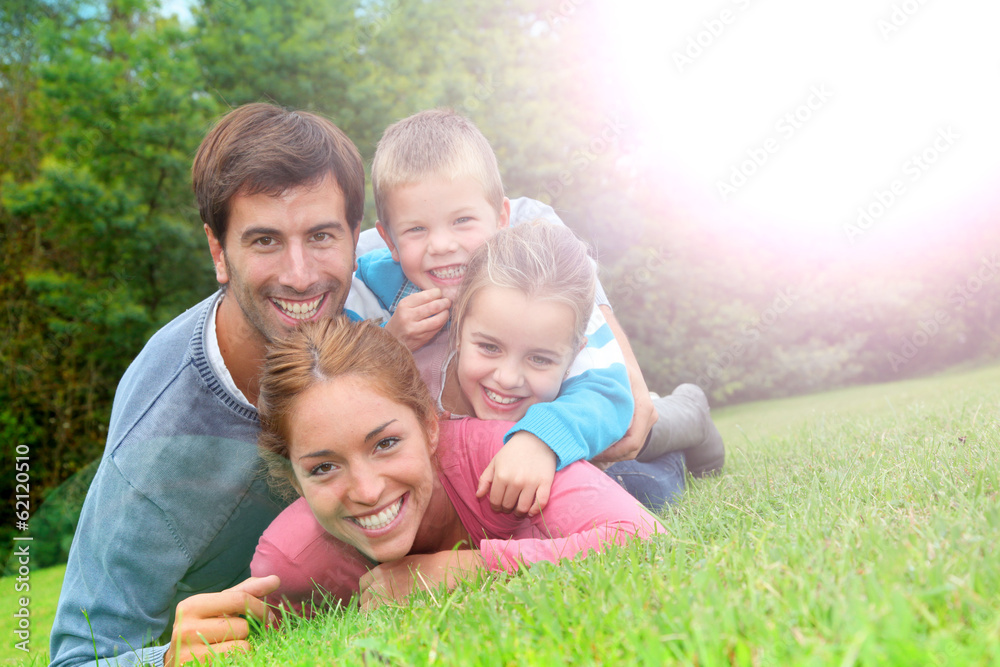 Portrait of happy family laying in country field Portrait of happy family laying in country field