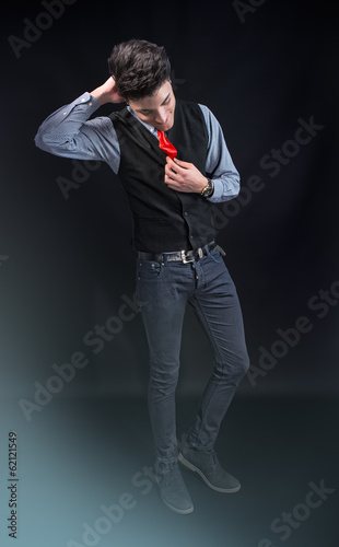Fashion young man in jeans and red tie