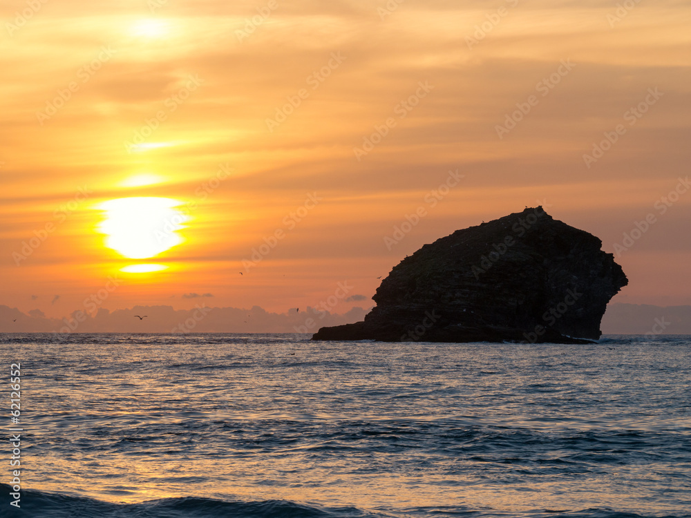 Sunset over the sea and Gull Rock, Portreath, Cornwall England.