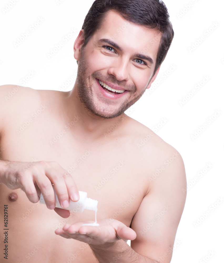 Young happy handsome man pours lotion. Young happy handsome man pours lotion.