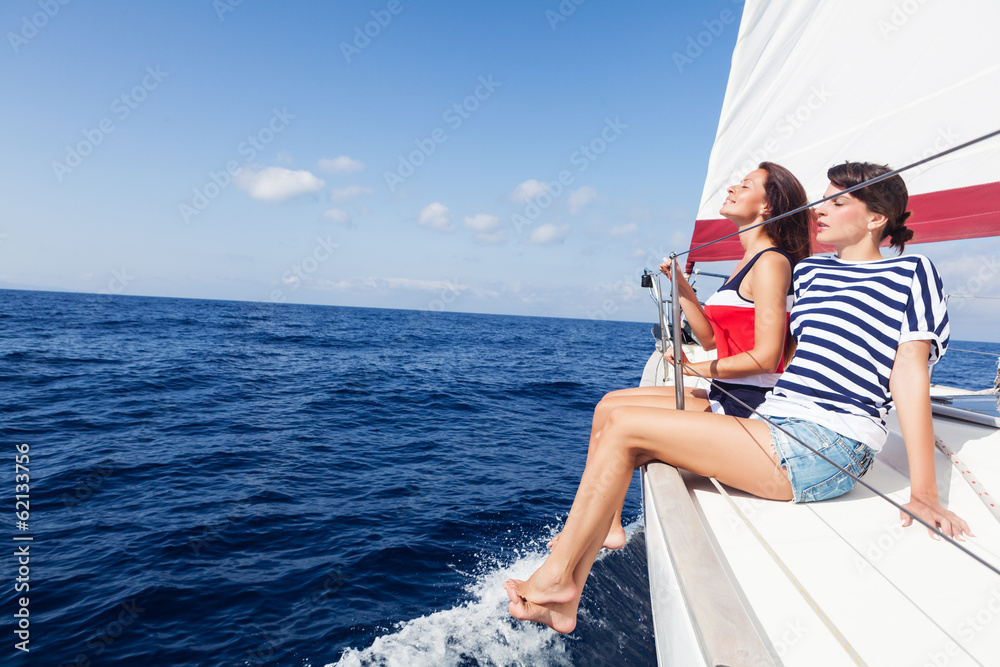 Happy women on the bow of a Sail Boat. Copy space