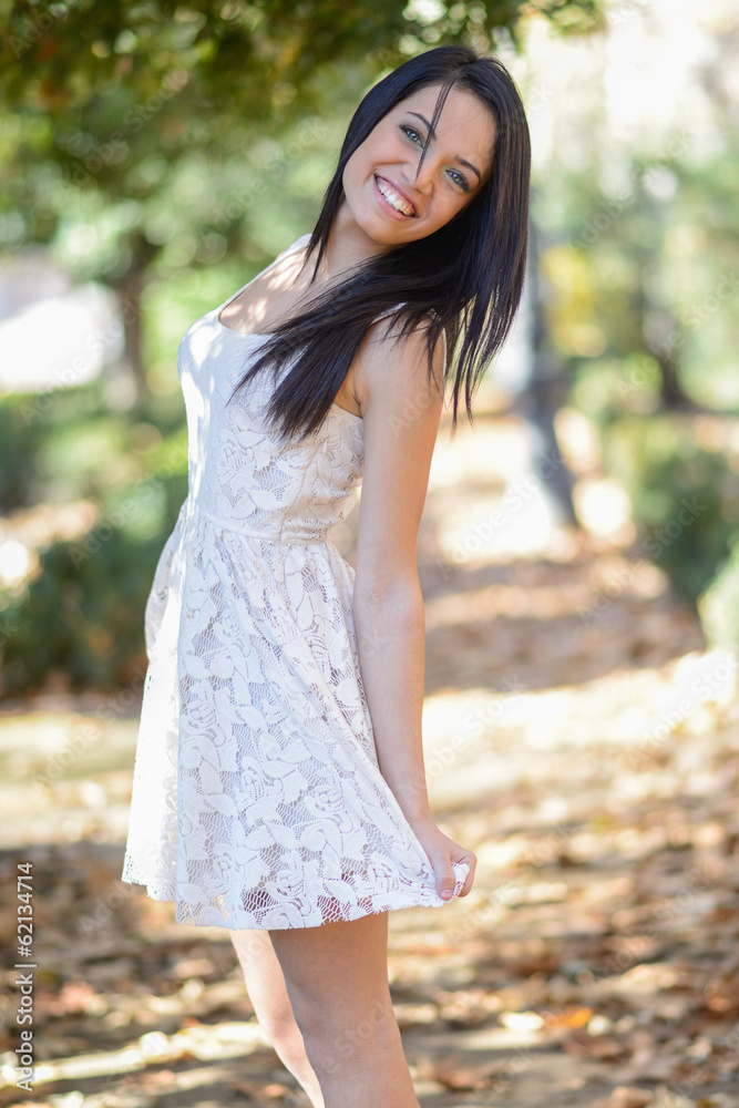 Young woman wearing white dress in urban park Young woman wearing white dress in urban park
