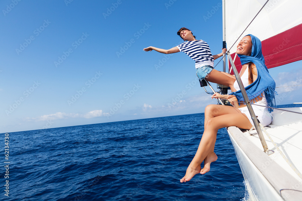 Naklejka premium Happy women on the bow of a Sailboat.Copy space