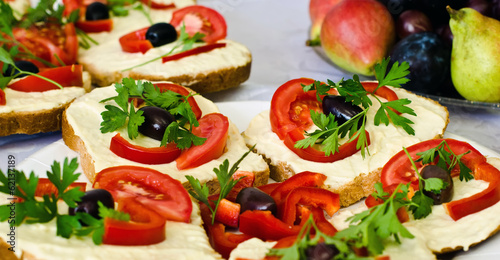 Tray with vegetarian sandwich garnished with tomato and parsley