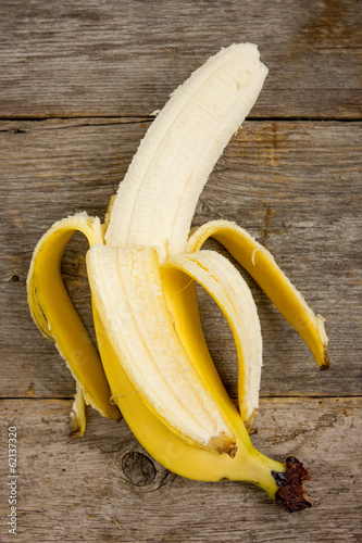 Peeled  banana on the wood background