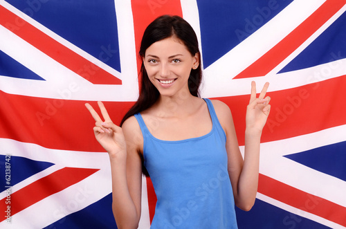 Portrait of a beautiful British girl smiling and signing victory