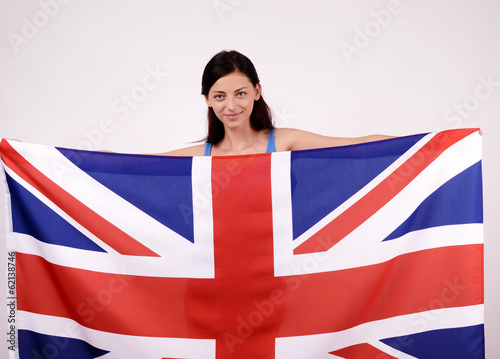 Beautiful British girl smiling holding up the UK flag. 