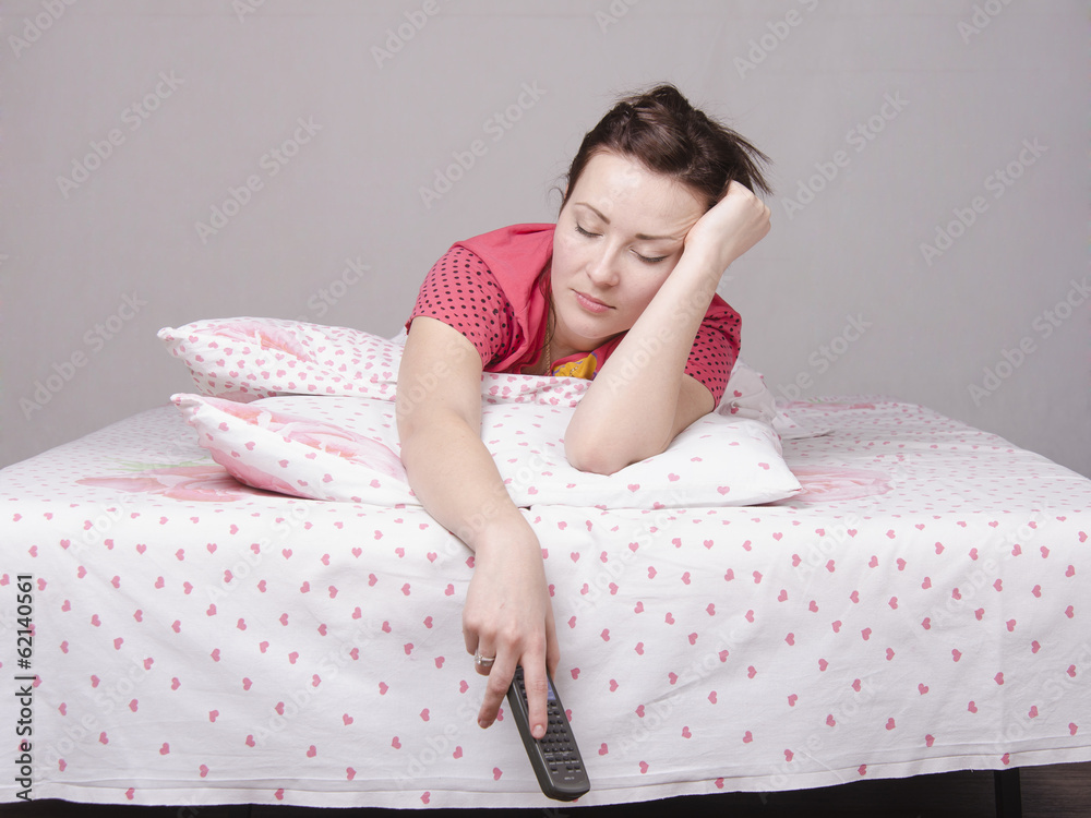 Проснувшаяся молодая девушка выпрямляется в постели
