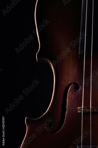 Scratched violin on dark background. Closeup view.