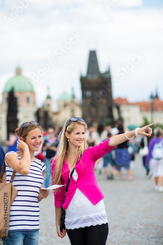 Two female tourists walking along the Charles Bridge
