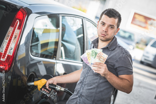Man with Banknotes at Gas Station