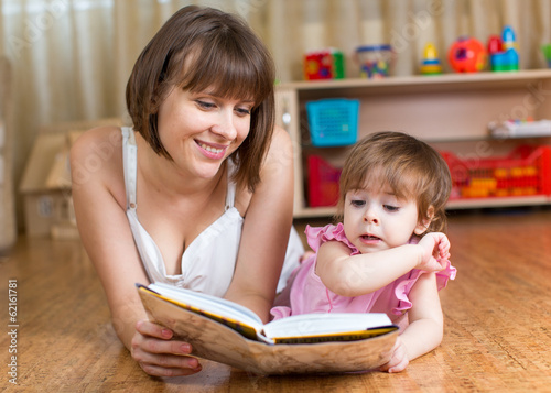 mother reading a book to child at home