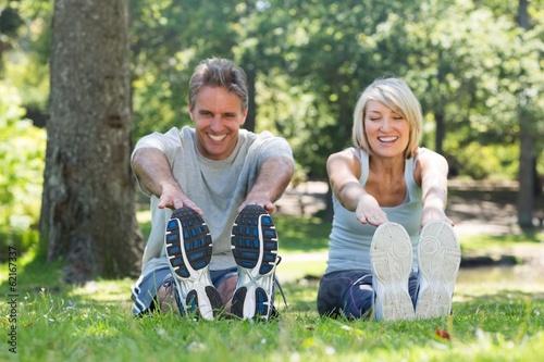 Happy couple stretching in park