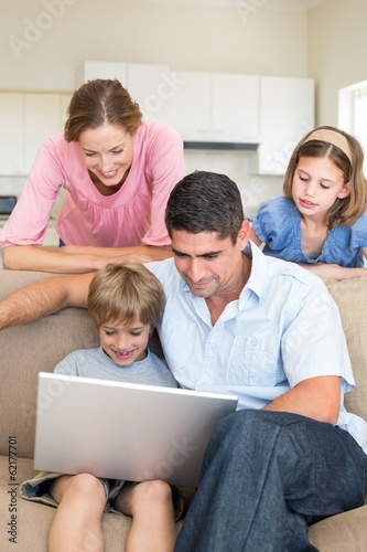 Family using laptop in living room