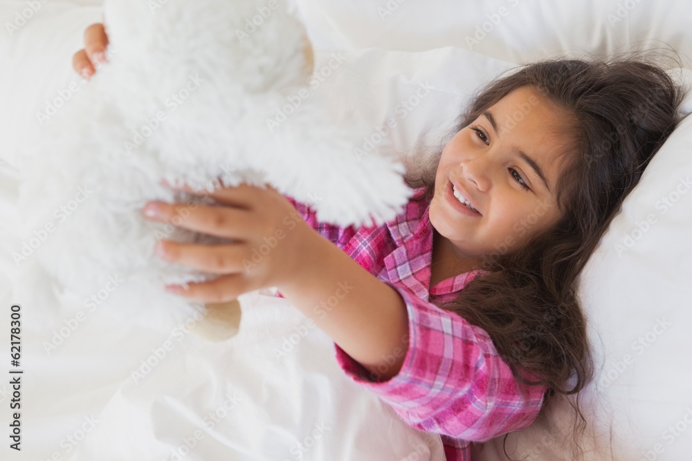 Smiling girl with stuffed toy resting in bed Smiling girl with stuffed toy resting in bed
