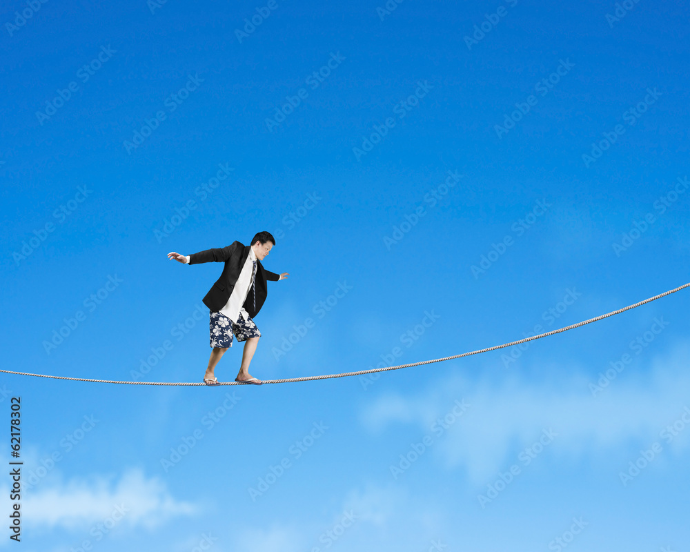 Man balancing on rope with sky Man balancing on rope with sky