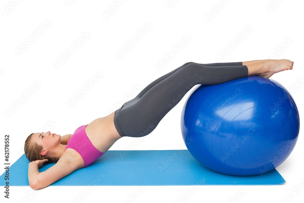 Side view of a fit woman exercising with fitness ball Side view of a fit woman exercising with fitness ball