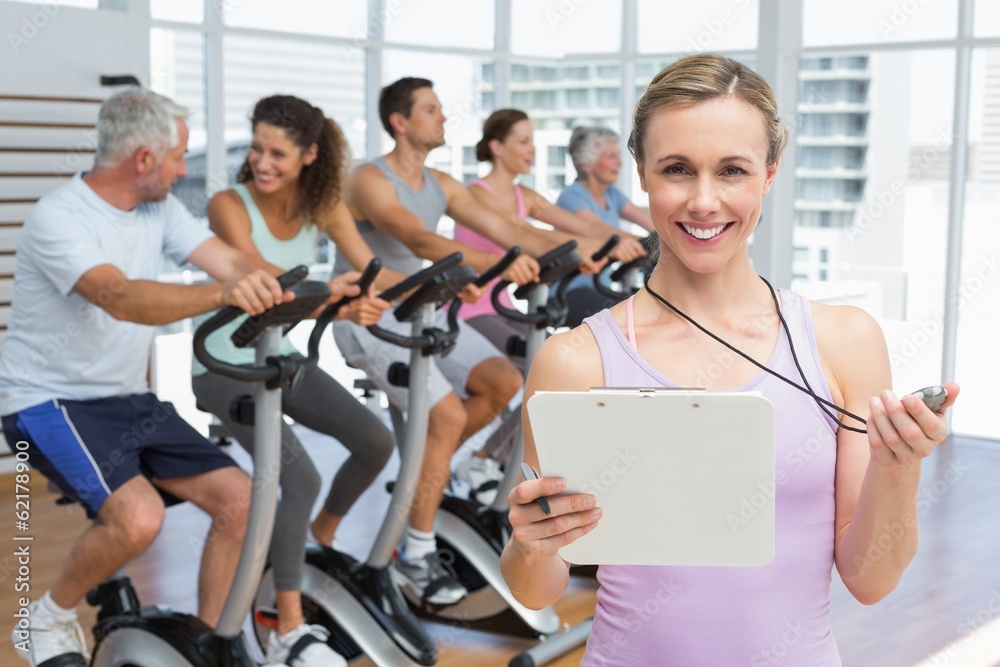Female trainer with people working out at spinning class Female trainer with people working out at spinning class