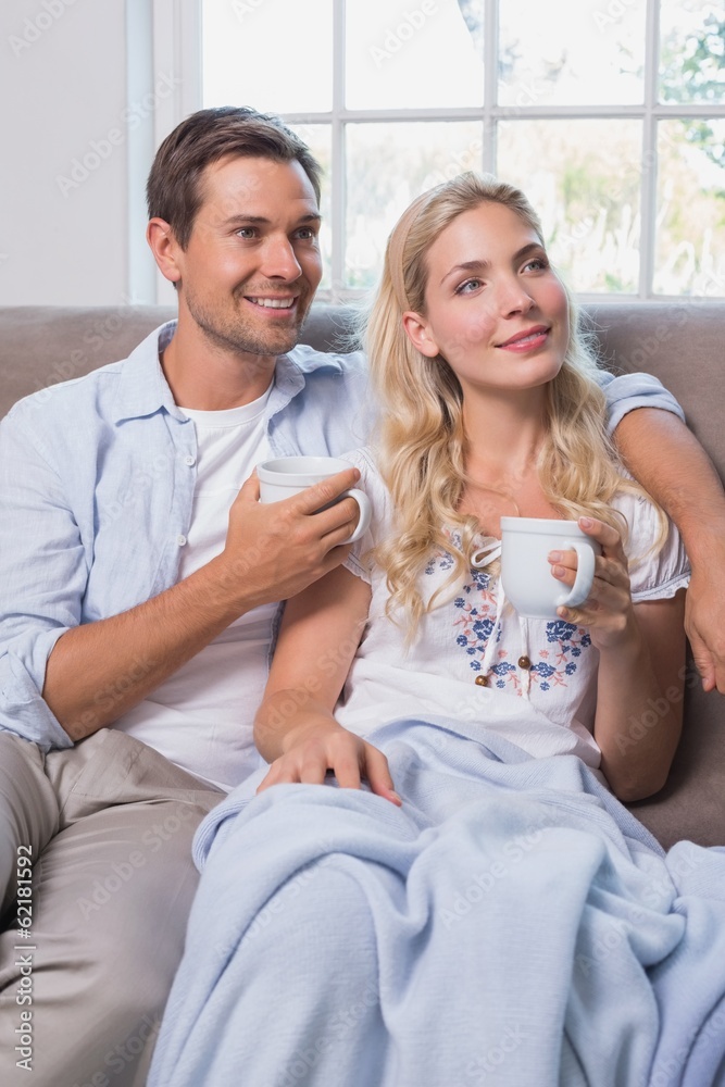 Relaxed couple with coffee cups in living room at home Relaxed couple with coffee cups in living room at home