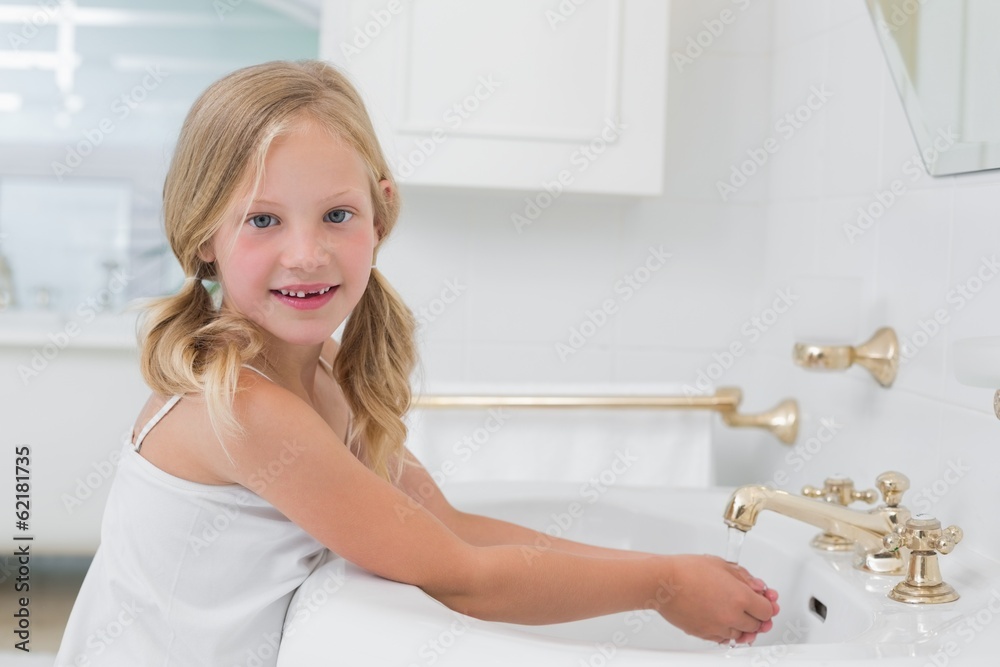 Portrait of a cute girl washing hands at washbasin Portrait of a cute girl washing hands at washbasin