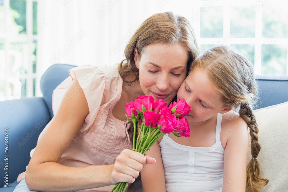 Mother and daughter smelling flowers in the living room Mother and daughter smelling flowers in the living room
